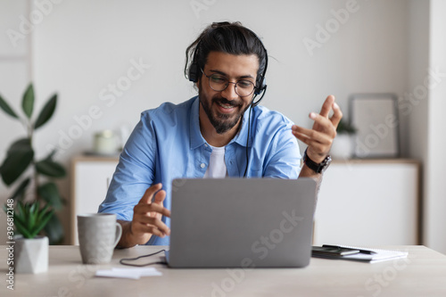 Web Conference. Positive Western Guy In Headset Making Video Call Via Laptop