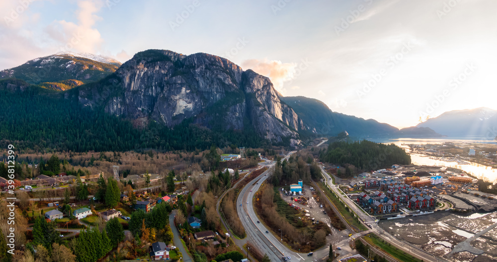 Aerial Panoramic View of Sea to Sky Highway, Residential Homes and Chief Mountain in the background. Colorful Sunset Sky. Taken in Squamish, North of Vancouver, British Columbia, Canada.