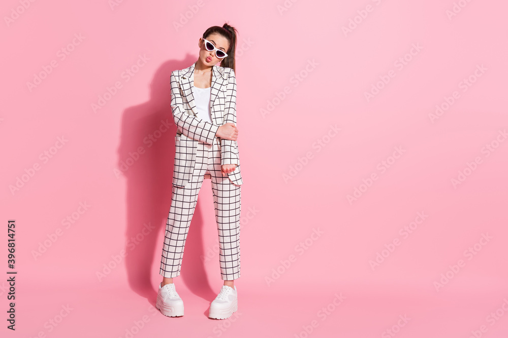 Photo portrait full body view of cute shy girl pouting isolated on pastel pink colored background with blank space Photo portrait full body view of cute shy girl pouting isolated on pastel pink colored background with blank space