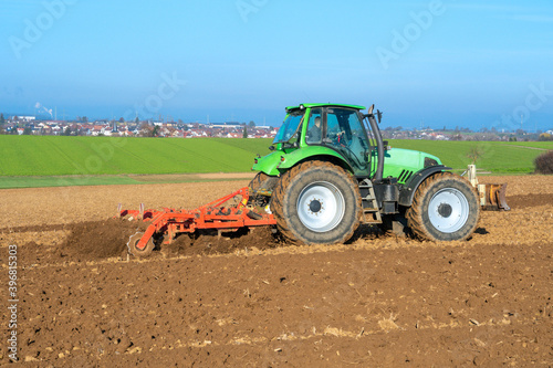 Traktor mit Egge auf einem Acker