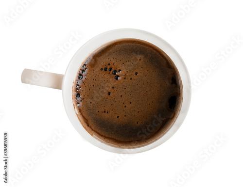 A mug of strong black coffee with foam in a white mug. On a white isolated background. Top view