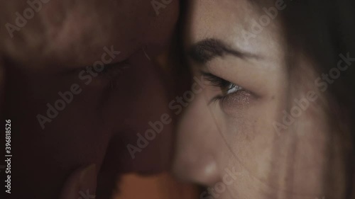 Young couple in romantic affection touching each other in slow motion. Man and woman have close eye intimate contact. Looking into eyes with love and passion. Lovers kiss at sensual momet of intimacy. photo