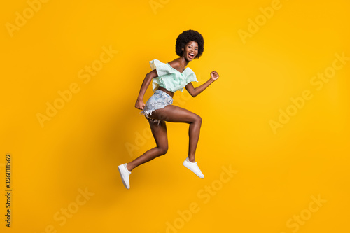 Full length body size side profile photo of jumping high girl running fast sale laughing isolated on vibrant yellow color background