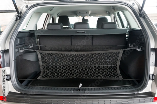 The luggage net for groceries hangs in the open trunk of the car. © papava