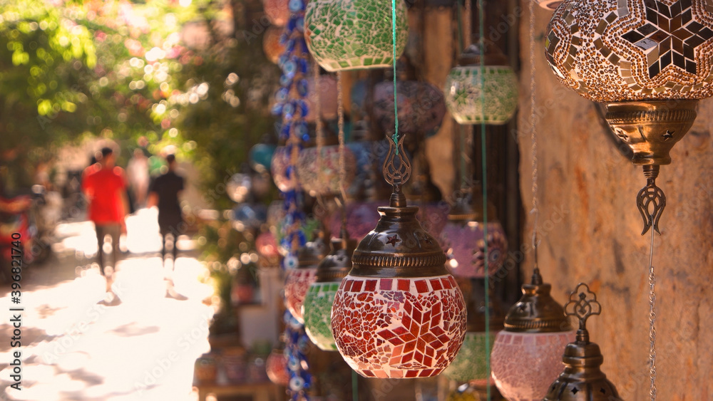 Obraz premium Turkish decorative lamps for sale at street market. Turkish mosaic lanterns hanging on the wall. Traditional souvenirs in old city of Antalya.