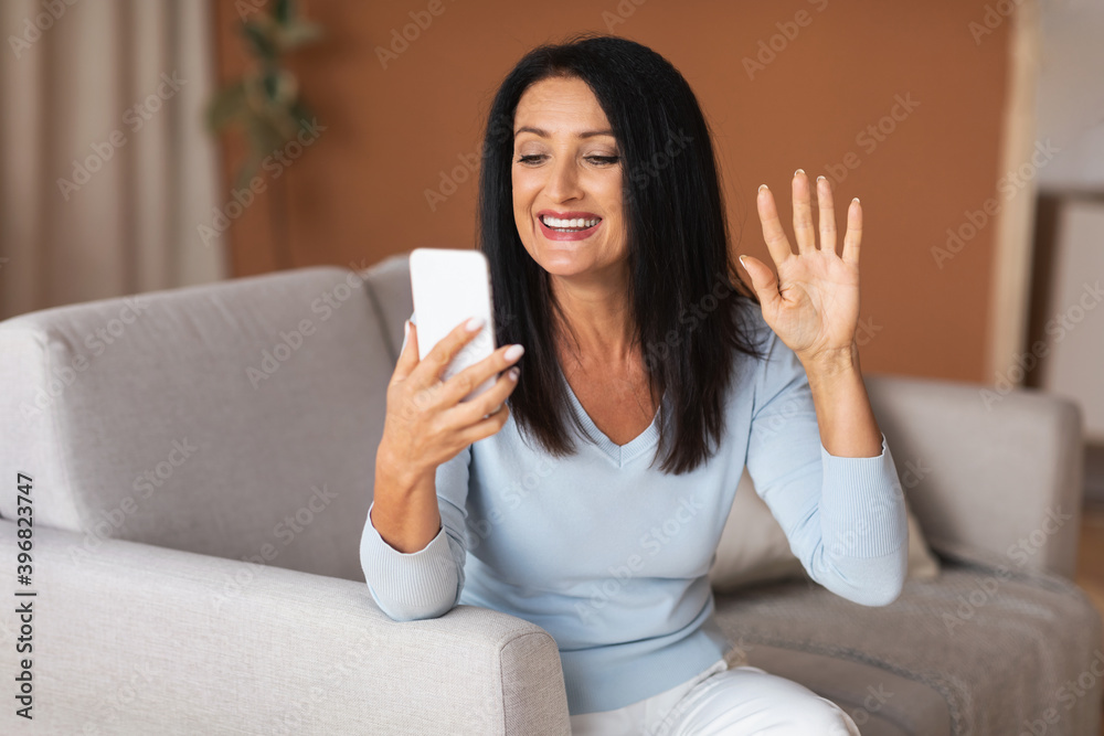 Happy woman using mobile phone for video call and waving Happy woman using mobile phone for video call and waving