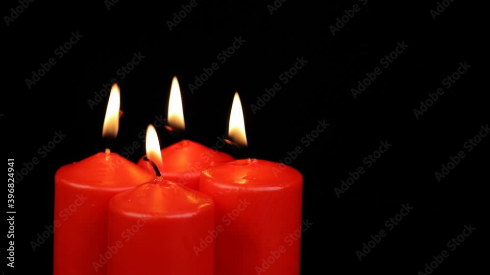 Rotating four red candles burning fire slowly spinning on a black background Rotating four red candles burning fire slowly spinning on a black background