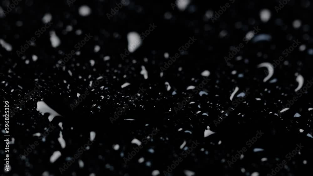 close-up macro of water droplets backlight and light on black mirror glass background. rotating close-up macro of water droplets backlight and light on black mirror glass background. rotating
