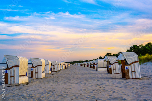 Fototapeta Naklejka Na Ścianę i Meble -  Juliusruh, Germany - 9. September 2020: Quiet sunset at the beach of Juliusruh on the island of Ruegen with beach chairs on the sandy beach with the Baltic Sea in the background