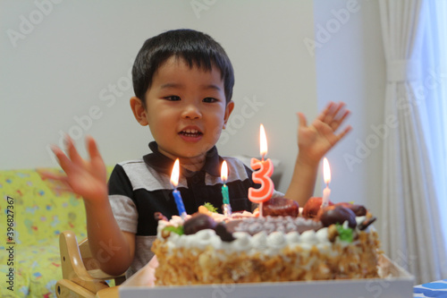 3歳の誕生日を祝ってもらい喜ぶ男の子と誕生日ケーキ

