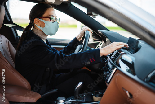 Focused businesswoman in face mask using navigator while driving car © Drobot Dean