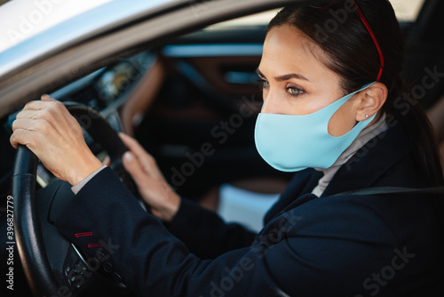 Beautiful confident focused businesswoman in face mask driving car © Drobot Dean