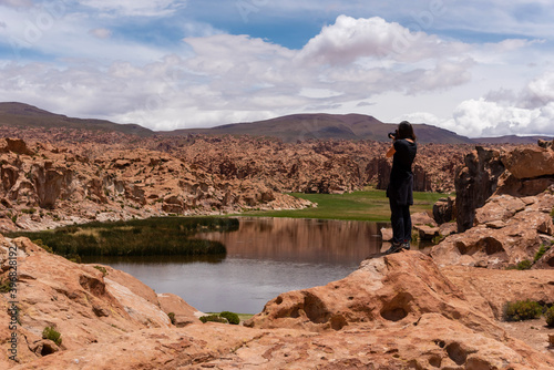 Woman taking a photo of a scenic landscape in the southwest of the Bolivian altiplano