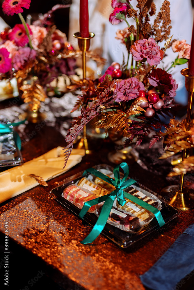 Sweet desserts in a plastic box on a decorated wedding table. Choosing a wedding cake. Cake fillings. Blurred background and selected focus.