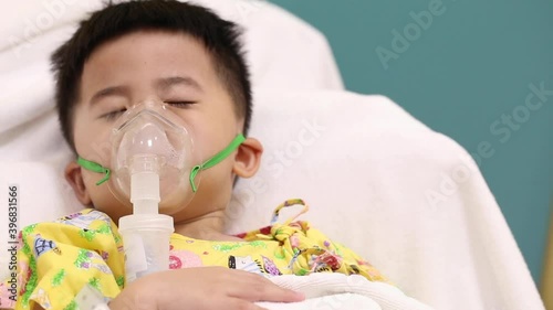 Asian little boy making inhalation with nebulizer at hospital, Nebulization concept photo