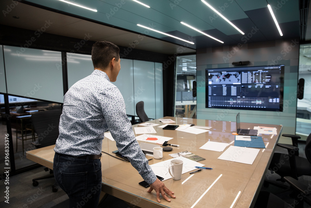 Man standing facing digital wall screen in meeting room Stock Photo ...