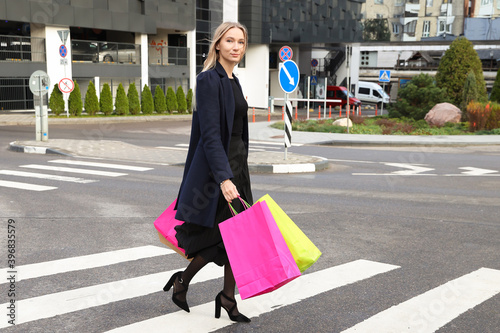 A young woman walks down the street with shopping bags © makedonski2015