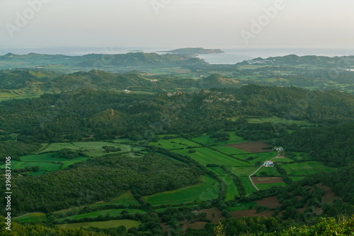 View of menorca from Monte Toro. Green fields and coast of the Mediterranean Sea in the distance. 