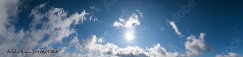 Blue sky with clouds in sunlight  wide cloudscape background panorama