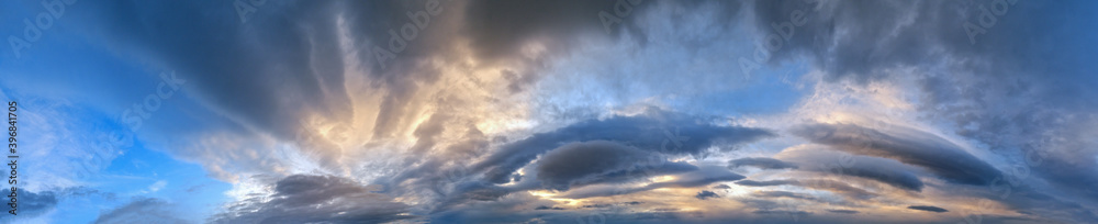 Fluffy clouds in evening overcast sky panoramic view. Climate, environment and weather concept sky background. Fluffy clouds in evening overcast sky panoramic view. Climate, environment and weather concept sky background.