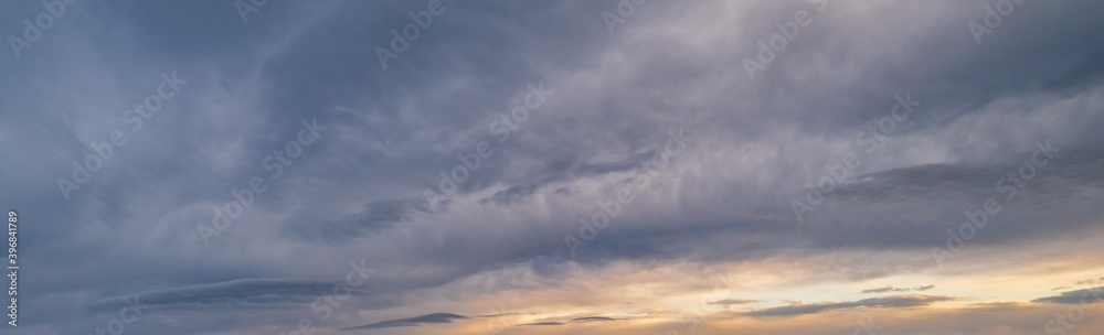 Fluffy clouds in evening overcast sky panoramic view. Climate, environment and weather concept sky background.