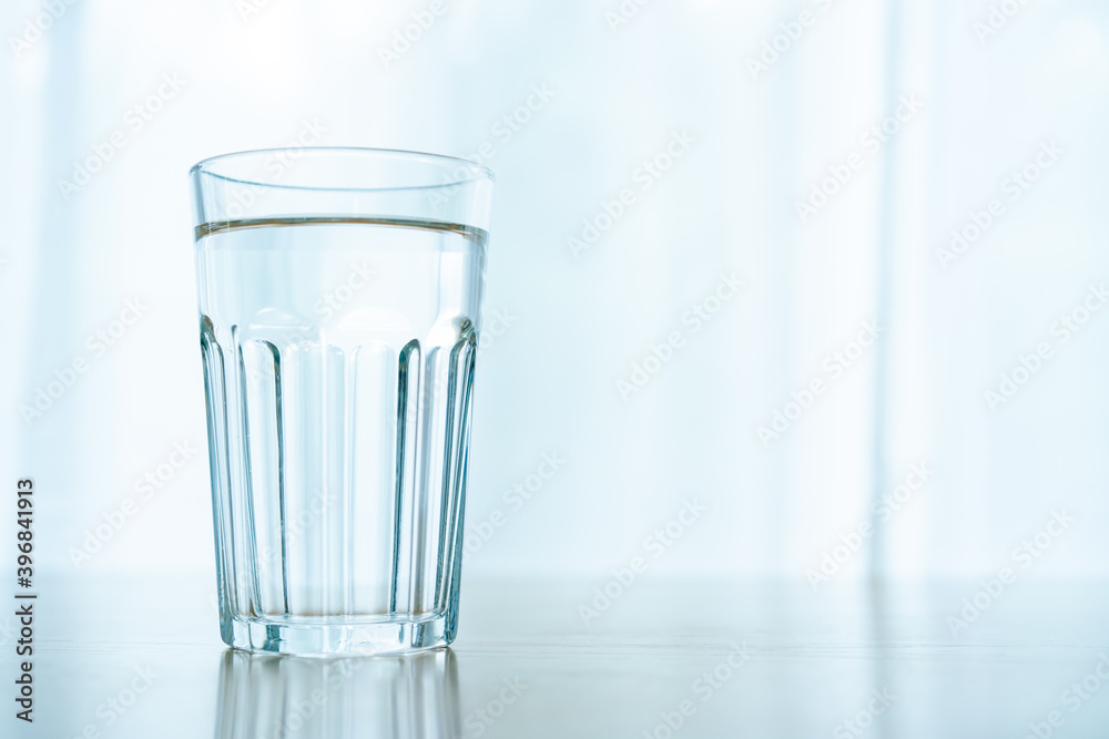 Drinking water in a glass left on the table in office, work life balance concept with copyspace. Modern woking lifestyle and healthcare Drinking water in a glass left on the table in office, work life balance concept with copyspace. Modern woking lifestyle and healthcare