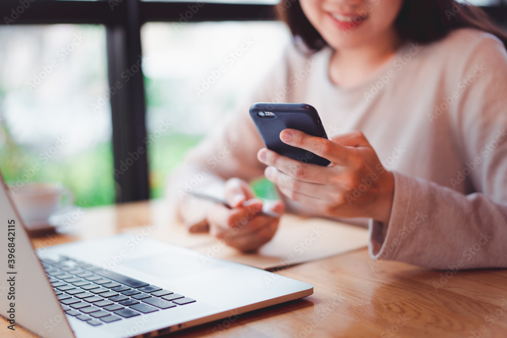 Unrecognizable cheerful young businesswoman reading a message on a smartphone close up. Unrecognizable cheerful young businesswoman reading a message on a smartphone close up.