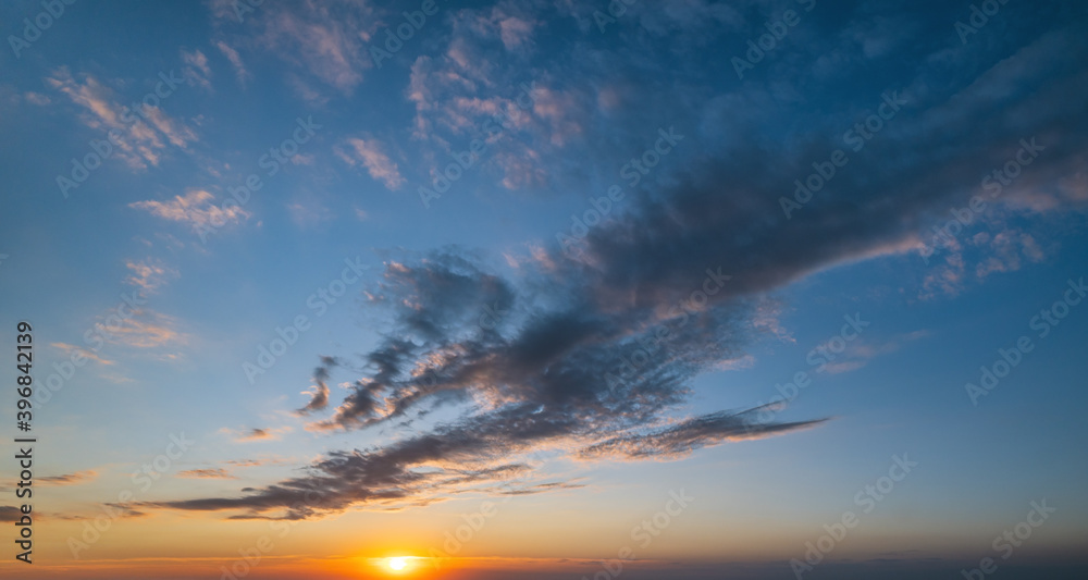 Fototapeta premium Fluffy clouds in evening sunset sky panoramic view. Climate, environment and weather concept cloudscape background.