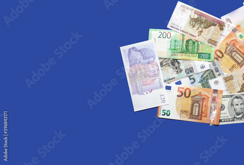 Photo of rubles bank notes from Russia, pounds bank notes, euro banknotes, dollars on blue background. Money consept