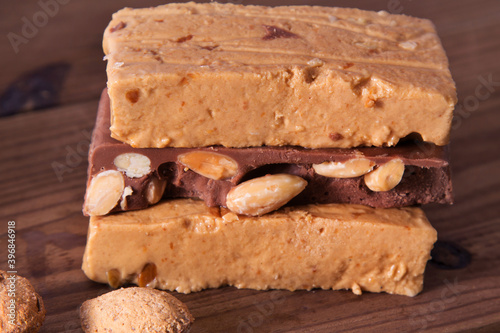 Almond nougat, typical Christmas dessert on wooden background