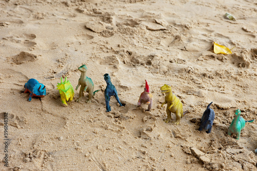 Fototapeta Naklejka Na Ścianę i Meble -  many plastic dinosaurs at the beach