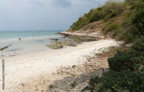 People sunbathe and swim.People walk on the beach after low tide