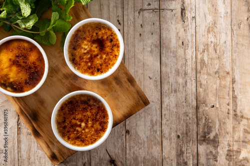 Photos Homemade creme brulee in bowl on wooden table