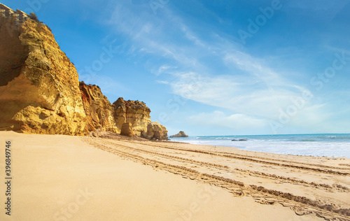 .beautiful ocean shore with clean yellow sand at sunset with a picturesque sky and cliff. summer in portugal in algarve