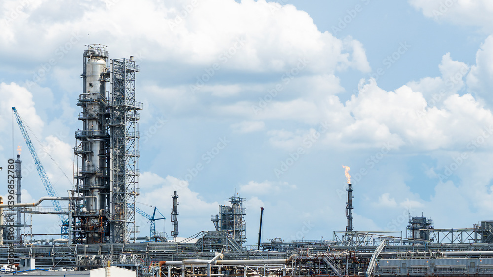 Refinery process area of petrochemical plant on classic blue sky with clouds background. Oil refining concept. Refinery process area of petrochemical plant on classic blue sky with clouds background. Oil refining concept.
