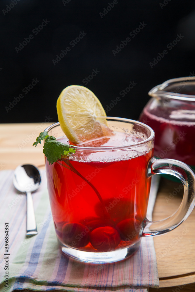 Berry tea in a cup with lemon on a napkin next to a spoon. Berry tea in a cup with lemon on a napkin next to a spoon.