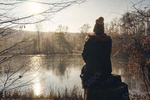 Foto A Women is sitting alone on a tree stump and gaze into the distance
