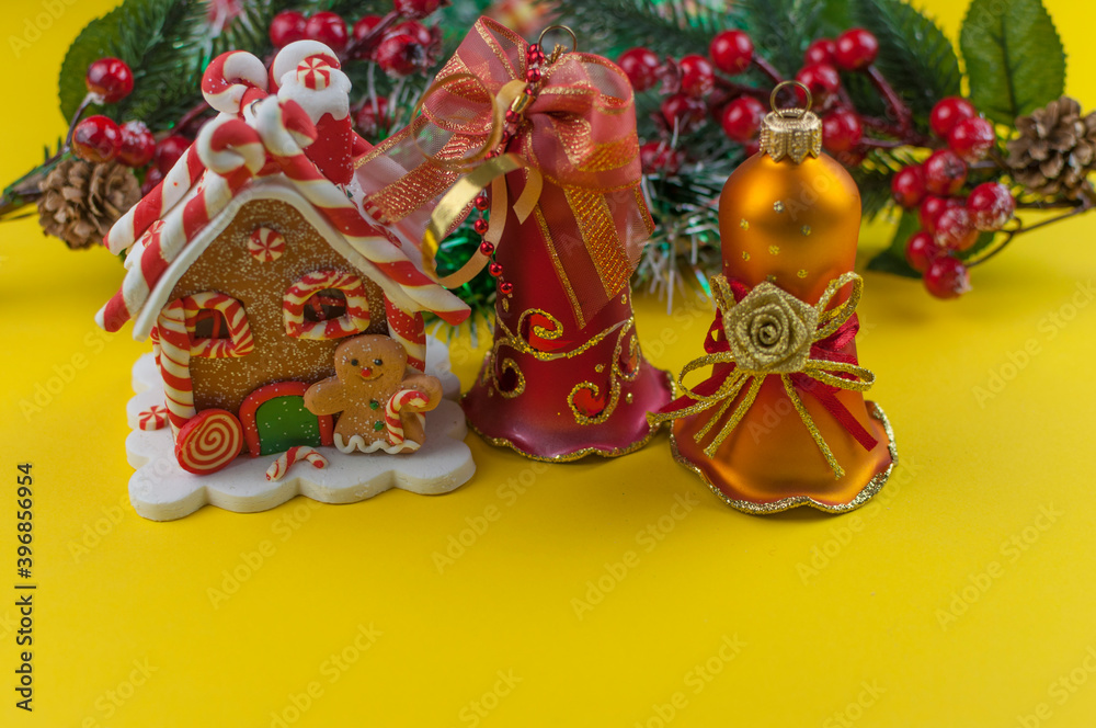 christmas decorations with house, and bells on yellow background