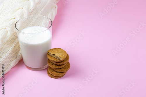glass of milk with biscuits and wool sweater
