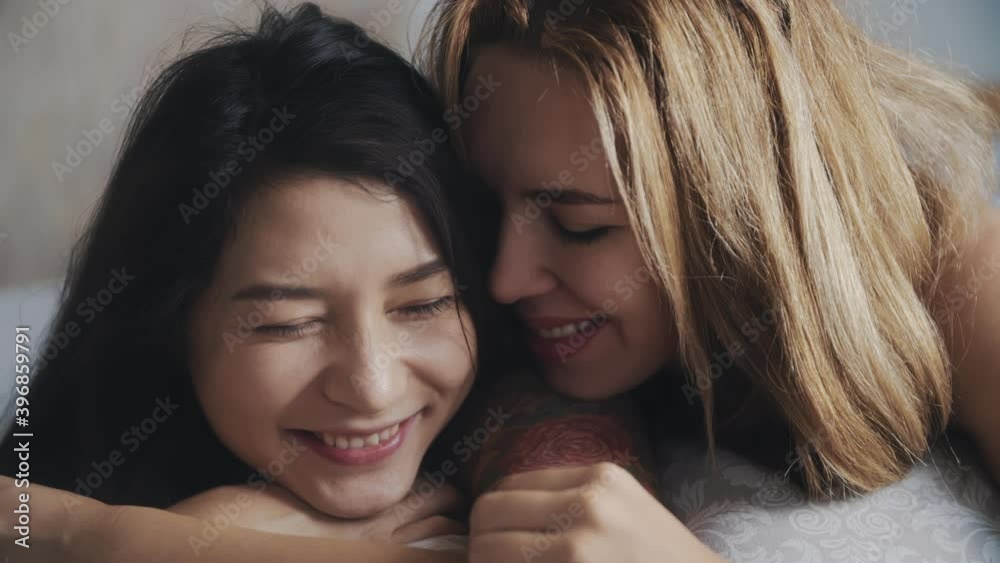 Homosexuals lesbian couple in bed, sharing kiss and care in the morning. LGBTQ, pride event, LGBT pride month, friendship, homosexual, lesbian concept. Two women sharing love and support. Homosexuals lesbian couple in bed, sharing kiss and care in the morning. LGBTQ, pride event, LGBT pride month, friendship, homosexual, lesbian concept. Two women sharing love and support.