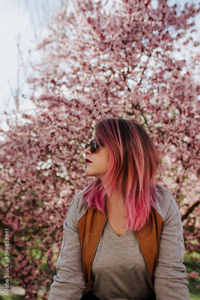 Woman with pink hair in pink almond tree Woman with pink hair in pink almond tree