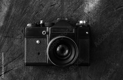 Retro camera lies on a wooden background, top view