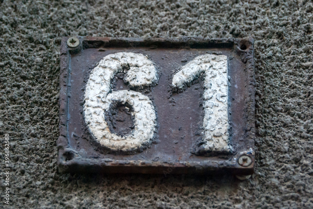 Old retro weathered cast iron plate with number 61 closeup Old retro weathered cast iron plate with number 61 closeup