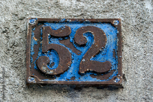 Old retro weathered cast iron plate with number 52 closeup
