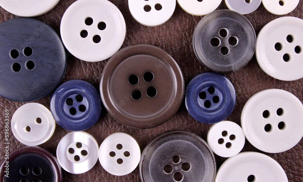 Set of different buttons on brown leather background