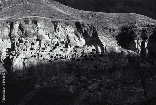 Black and white dramatic landscape of Vardzia- cave city in shadow conditions during sunrise. Unique and mysterious places in caucasus. photo