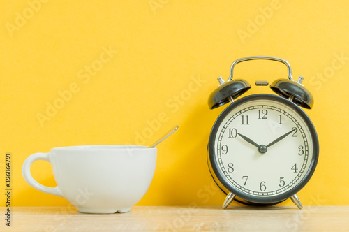 white tea mug and old alarm clock