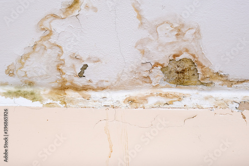 Rain water leaks on the ceiling because of damaged roof causing decay, peeling paint and moldy