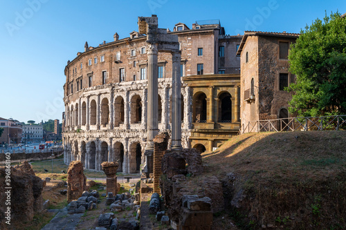 Photography Panorama of the Teatro di Marcello, with the remains of the temple of Apollo Sosiano between the Tiber river and the Capitoline Hill seen from the Jewish quarter, on a sunny day blue sky, clouds