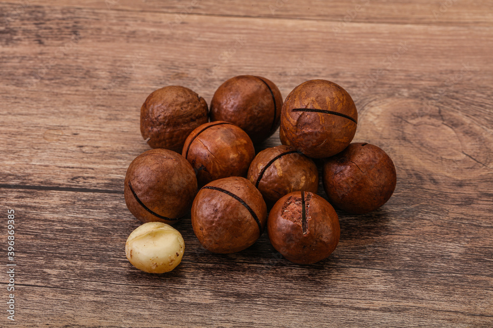 Brown macadamia nut heap over background Brown macadamia nut heap over background